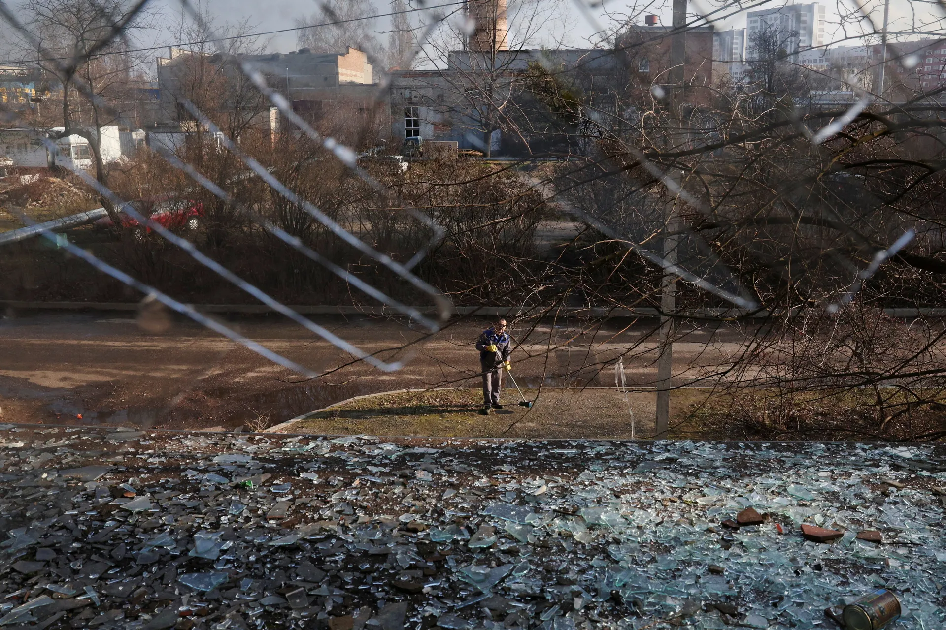 Робітник очищає розбите скло на промисловій території, пошкодженій внаслідок удару російського безпілотника в Харкові, Україна, 27 березня 2025 року.